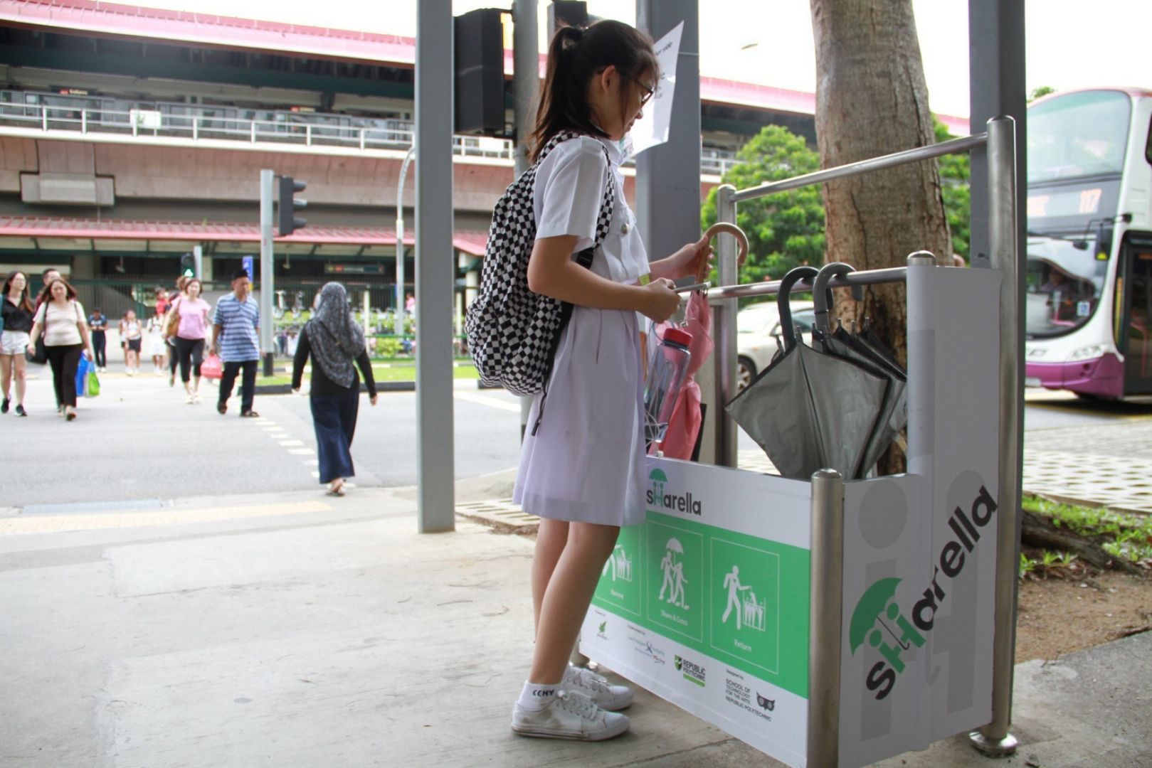 Noelle Neo, 13, taking an umbrella from the umbrella sharing scheme, Sharella's stand at Sembawang MRT station. Photo taken on Aug 22, 2017. u00e2u20acu201d Picture by Esther Leong/TODAY