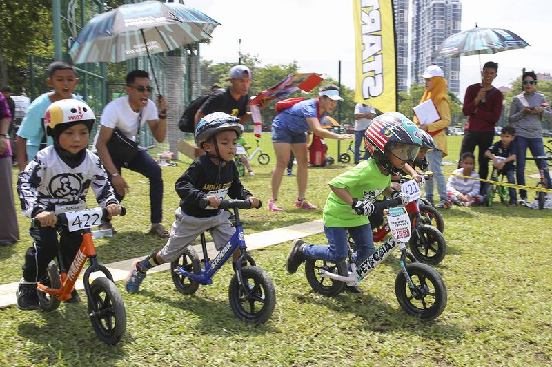 Tiny rider speed off at the starting line of Strider Cup Malaysia as parents cheer them off, in Pudu Ulu Park, Kuala Lumpur, July 16, 2017. u00e2u20acu201d Picture by Yusof Mat Isa