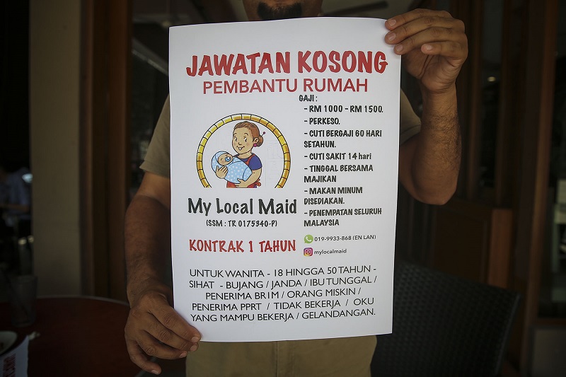 Wan Roslan goes around low-cost home areas and bus stations to put up his advertisement in hopes to recruit more women as maids. u00e2u20acu201d Picture by Yusof Mat Isa
