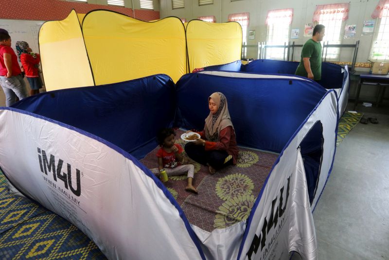 Mangsa banjir Nabilah Mat Zin 38, menyuapkan makanan kepada anaknya Nada Sofia Abdul Rahman, 4, di pusat pemindahan banjir di Sekolah Kebangsaan Taman Bukit Rambai, 9 Ogos 2017. u00e2u20acu201d Foto Bernama 