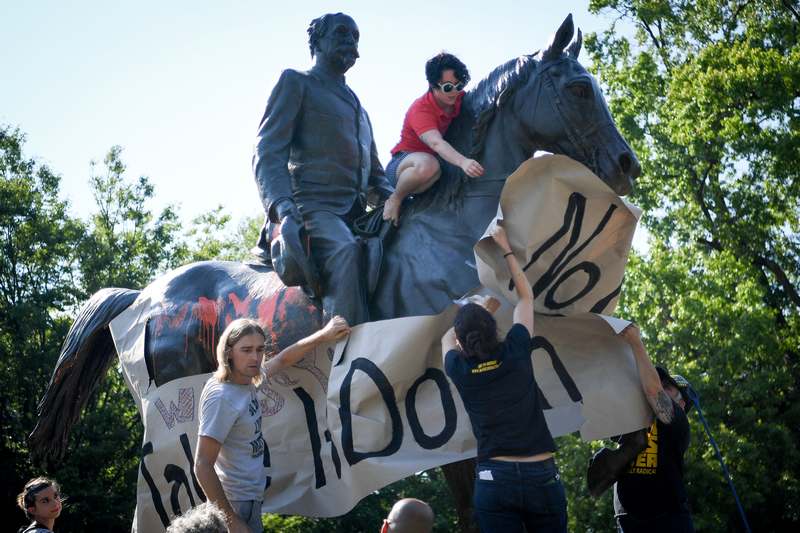 Members of a racial justice organisation hang a banner, reading 'Louisville, Take It Down' on a monument to Confederate soldier John B. Castleman in Louisville August 19, 2017. u00e2u20acu201d Reuters pic