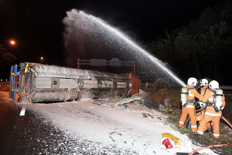 A hazmat team cleans up the acid that spilled from a tanker after a car crash at the North-South Expressway near Seremban August 12, 2017. u00e2u20acu201d Bernama pic