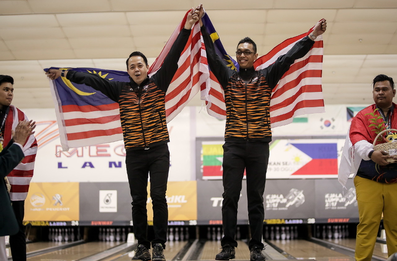 (From left) Alex Liew and Muhd Syafiq Ridhwan Abdul Malek pose with the Jalur Gemilang after winning the gold medal in the menu00e2u20acu2122s bowling doubles in Kuala Lumpur Sea Games 2017 at Sunway Mega Lanes, Petaling Jaya August 21, 2017. u00e2u20acu201d Bernama pic