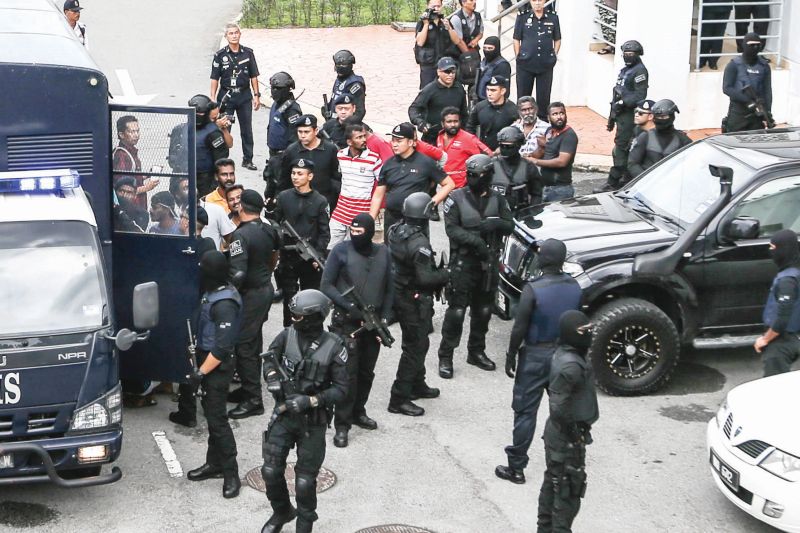 Heavily armed police personnel escort the accused back into a truck after their charges were read out to them at the Klang Sessions Court. u00e2u20acu201d Picture by Hari Anggara