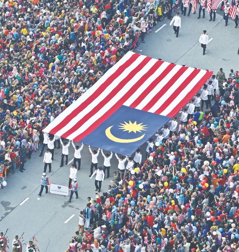 A Malaysian flag is paraded during the Merdeka celebrations in Kuala Lumpur last year. The writer says a citizen should be judged for his contributions to the nation instead of casting baseless aspersions on the individual. — Picture by Azneal Ishak 