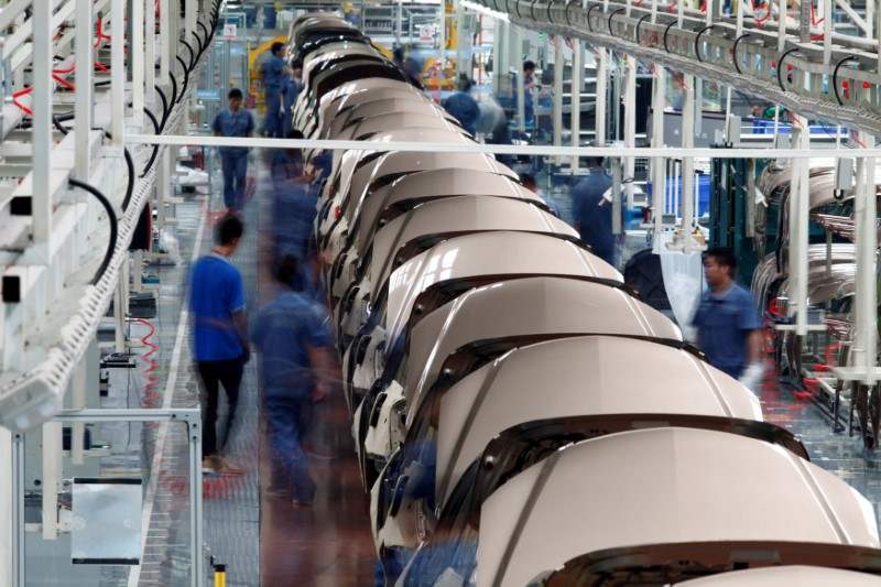 Employees work along a Geely Automobile Corporation assembly line in Cixi, Zhejiang province June 21, 2012. 