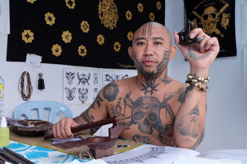 Lo uses a tattoo machine most of the time but is equally adept at hand tapping, which involves use of a needle tied to a stick. — Picture by KE Ooi