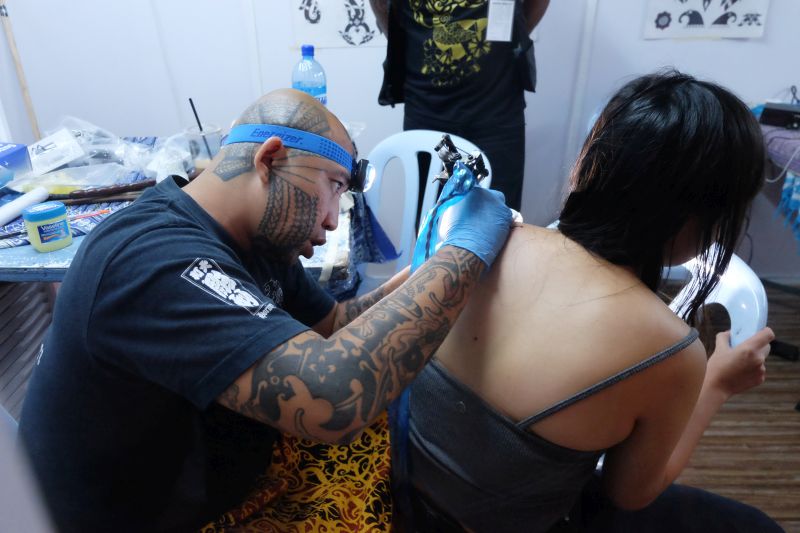 Jeremy Lo of Monkey Tattoo Studio is pictured working on a piece of tattoo at the Macam-Macam Asean event. — Picture by KE Ooi
