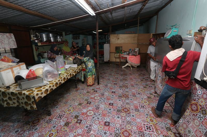 Flood victim Puteh Ndot, 81, (centre) helps to clean a house after the flood in Jasin, Melaka, August 15, 2017. u00e2u20acu201d Bernama pic