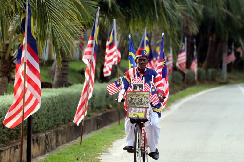 A. Sothi Vadamalai, 68, rides his antique bicycle, which is decorated with the Jalur Gemilang, around Melaka city, August 30, 2017. u00e2u20acu2022 Bernama pic
