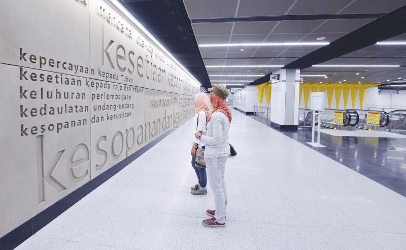 MRT users stop to admire the arresting visuals at the Merdeka MRT station such as this three-dimensional Rukunegara mural on August 28, 2017. u00e2u20acu201d Malay Mail pic