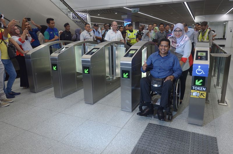 Datuk Seri Rohani Abdul Karim helping a disabled person use the facilities provided by MRT on the Sungai Buloh-Kajang (SBK) line at Tun Razak Exchange MRT (TRX) station, August 7, 2017. u00e2u20acu201dBernama pic