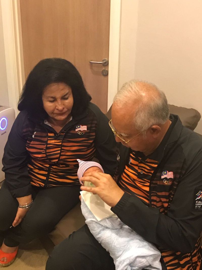 Datuk Seri Najib Razak carries his grandson while Datin Seri Rosmah Mansor looks on. u00e2u20acu2022 Picture via Twitter/najibrazak