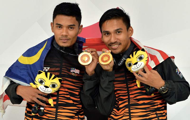 Rosli Mohd Sharif (left) and Mohd Taqiyuddin Hamid who won gold in the men's pencak silat artistic doubles at the Kuala Lumpur Convention Centre August 24, 2017. u00e2u20acu201d Bernama pic