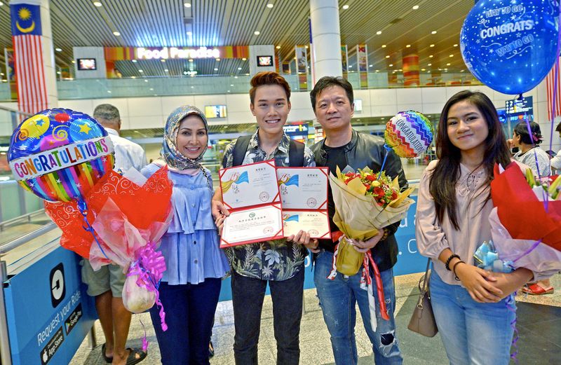 Muhamad Shahmeer Mohd Nashrul (second right) won second place in the Mandarin language competition in Changsha, China, is pictured on his arrival at KLIA, August 16, 2017. u00e2u20acu201d Bernama pic