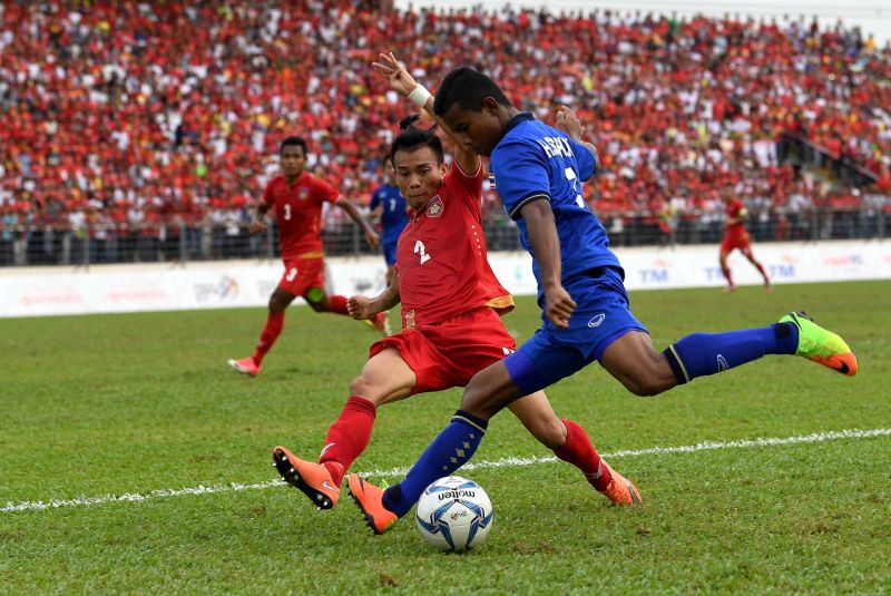 Thailand's player Sasalak Haiprakhon (right) is challenged by Manmar's player Nan Wai Min during the SEA Games Men's Football semifinal encounter at Selayang Stadium today. u00e2u20acu2022 Bernama pic