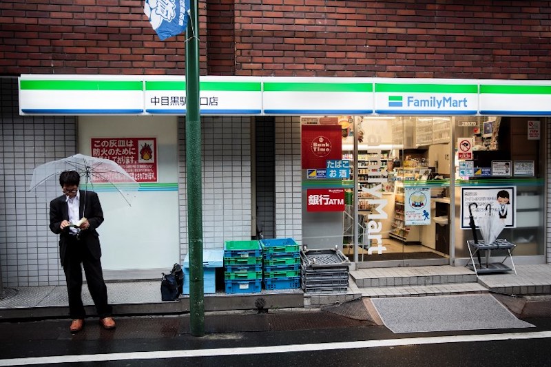 A man reads a book as he smokes next to a convenience store in the Nakameguro district in Tokyo September 4, 2017. u00e2u20acu201d AFP pic
