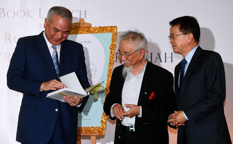 Sultan of Perak Sultan Nazrin Shah (left) reads the book titled, u00e2u20acu02dcTurbulence in Trying Timesu00e2u20acu2122 written by economist Prof Tan Sri Dr Lin See Yan (centre) after the launching ceremony on September 8, 2017, while Sunway University Chancellor Tan Sri Dr Je