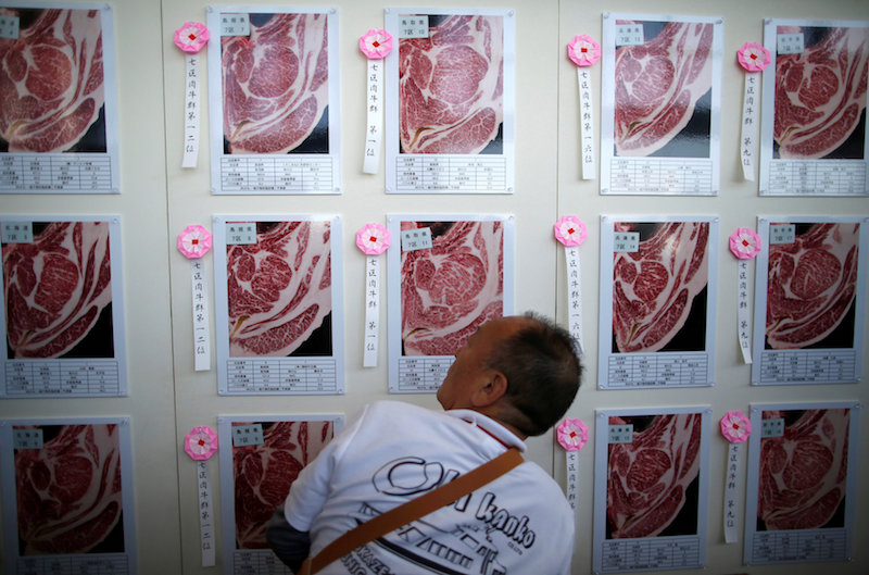 A man checks the pictures of award-winning beef at 11th National Japanese Beef Ability Expo, commonly known as Wagyu Olympics, in Sendai, northern Japan September 12, 2017. u00e2u20acu201d Reuters pic