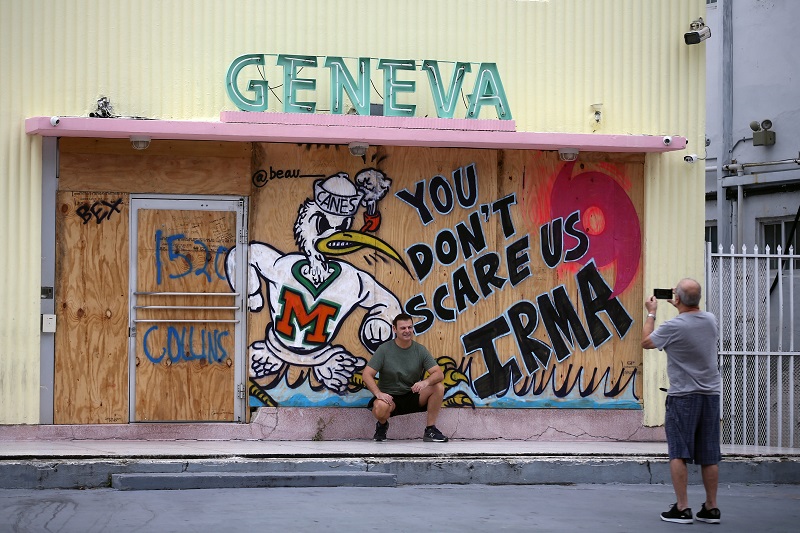 A tourist poses for a picture outside of a shop in South Beach prior to the arrival of Hurricane Irma to south Florida, in Miami September 9, 2017. 