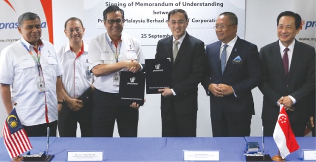 Prasarana president and group chief executive officer Azmi Abdul Aziz (third from left) and SMRT president and group CEO Desmond Kuek exchange documents after the signing of the MoU.u00e2u20acu201dPicture by Azneal Ishak
