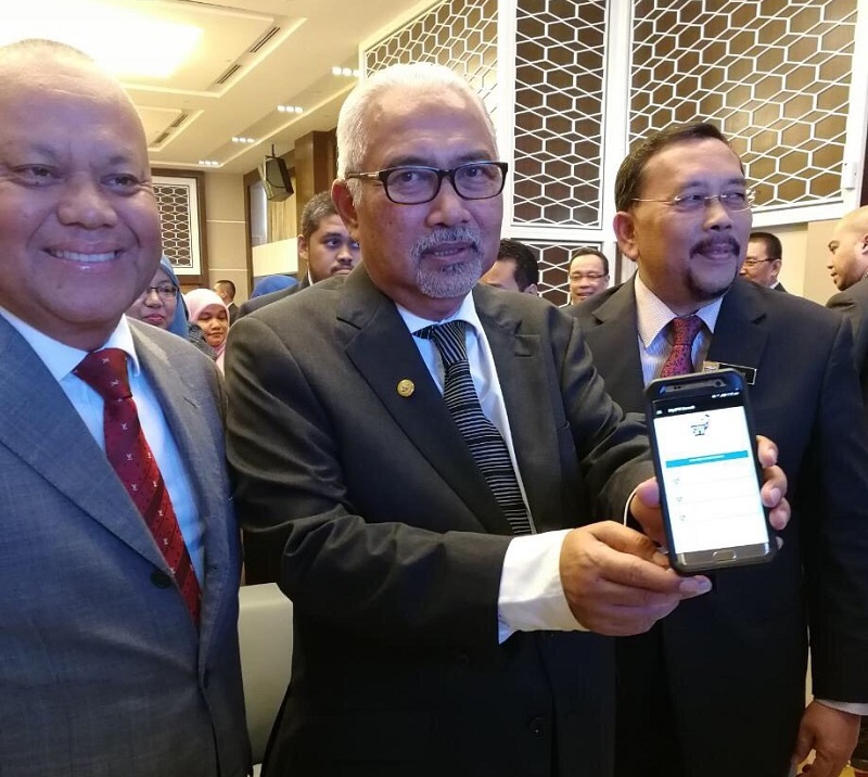 EC chairman Tan Sri Mohd Hashim Abdullah (centre) displays a smartphone with the ECu00e2u20acu2122s new app. u00e2u20acu201d Picture by Kamles