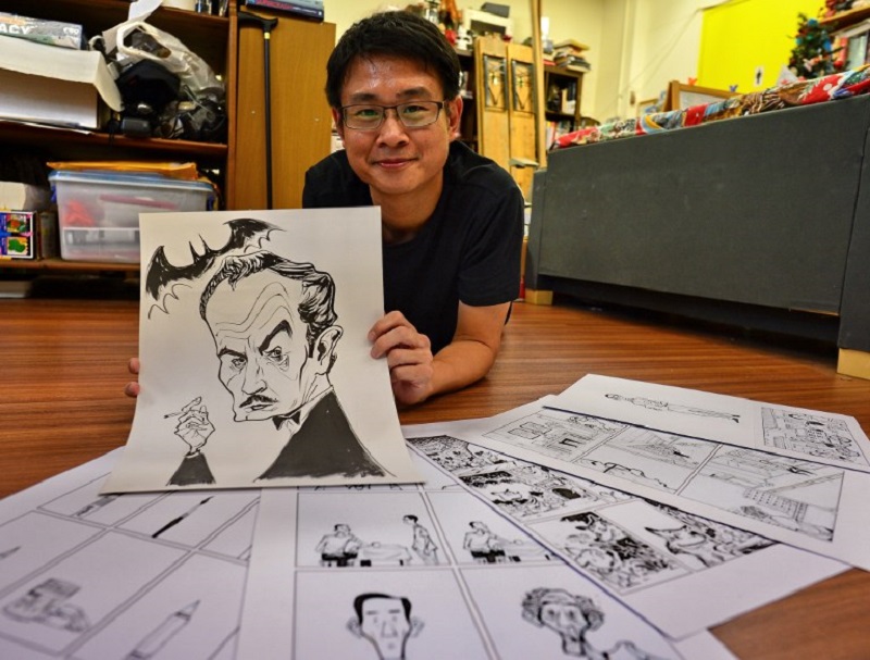 This photograph taken on August 3, 2017 shows Singaporean cartoonist Sonny Liew posing with his work at his office in Singapore. u00e2u20acu201d AFP pic