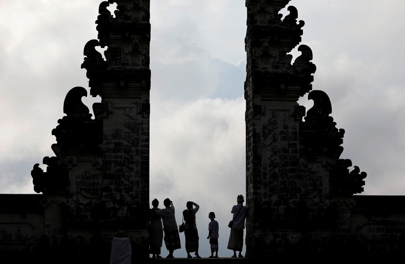 Balinese worshippers look at Mount Agung, enshrouded by clouds, from the gate of Penataran Agung Lempuyang temple, a day after the volcano's alert status was raised to the highest level in Bali September 23, 2017. u00e2u20acu201d Reuters pic 