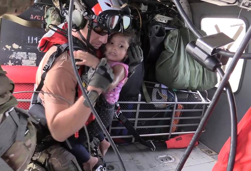 A US Air Force pararescueman carries a young girl to the safety of a HH-60 Pave Hawk helicopter over flood waters caused by Hurricane Harvey in Houston in a still image from video September 1, 2017. u00e2u20acu201d Reuters pic 