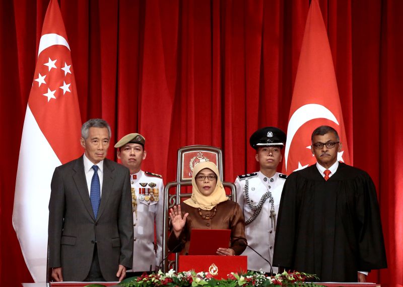 Halimah Yacob (centre) takes the oath of office while flanked by Singapore Prime Minister Lee Hsien Loong and Chief Justice Sundaresh Menon during the presidential inauguration ceremony at the Istana Presidential Palace in Singapore September 14, 2017. u00e2u20ac
