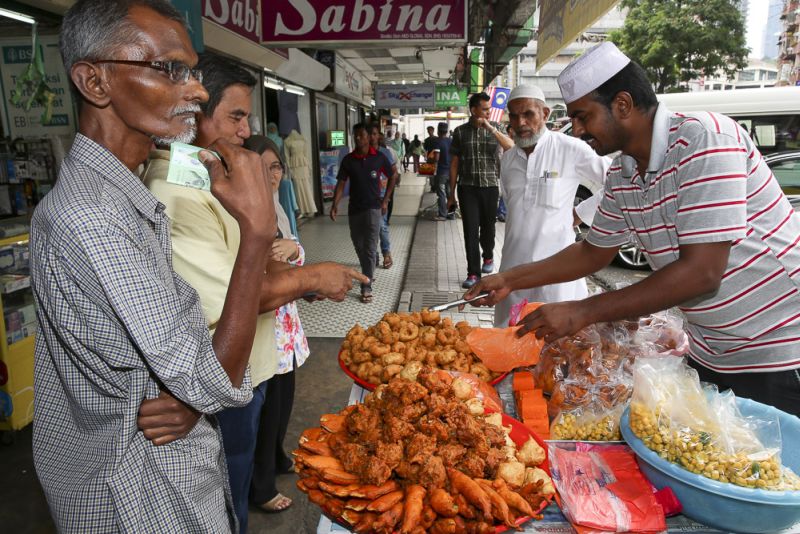 Indian snacks trader Rahman Varusai selling 'vadai', boiled nuts and onion fritters at his roadside stall.