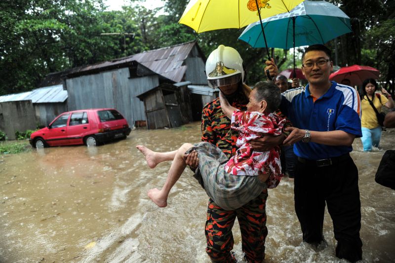 Anggota bomba mendukung seorang warga emas, Tan Siew Kee, 91, ekoran rumahnya dinaiki air di Kampung Seberang Perak 21 Sept 2017. u00e2u20acu201d Foto Bernama