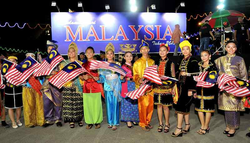 Participants in Sabah tribal costumes waving the Malaysian flag before the start of Malaysia Day celebrations at the Likas Sports Complex, Kota Kinabalu September 16, 2017. u00e2u20acu201d Bernama pic