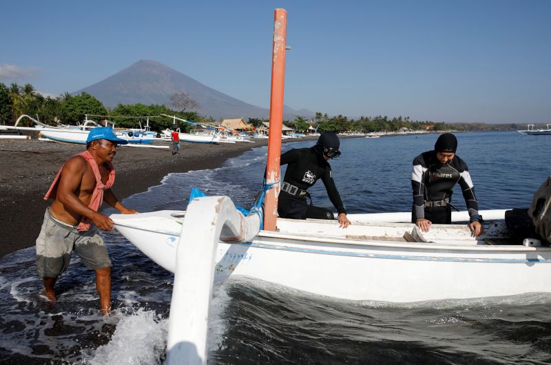 Mount Agung is seen in the background as tourists from China depart for a dive in Bali, , September 27, 2017. u00e2u20acu201d Reuters pic