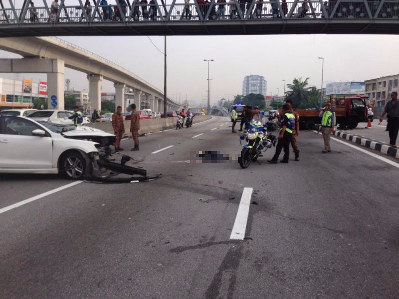 Mayat pemandu kereta putih (kiri) masih di tengah jalan selepas digilis lori yang terbabas ke kanan jalan. u00e2u20acu2022 Foto ihsan Facebook/Balai Bomba dan Penyelamat Puchong