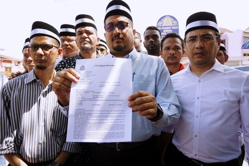 Kedah Umno Youth chief Datuk Shaiful Hazizy Zainol Abidin (centre) showing the police report lodged against social media users who had allegedly insulted the late Sultan Abdul Halim Mu'adzam Shah, at Alor Star District Police Headquarters, September 13, 2