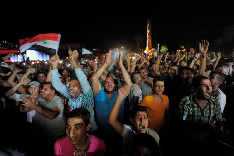 People gather and cheer as they watch the World Cup 2018 qualifiers between Iran and Syria, in Damascus, Syria, September 5, 2017. u00e2u20acu201d Reuters pic