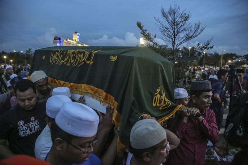 Men are seen carrying a coffin bearing the remains of victims of the tahfiz school fire during a mass funeral at the Tanah Perkuburan Islam Raudhatul Sakinah in Gombak September 15, 2017.