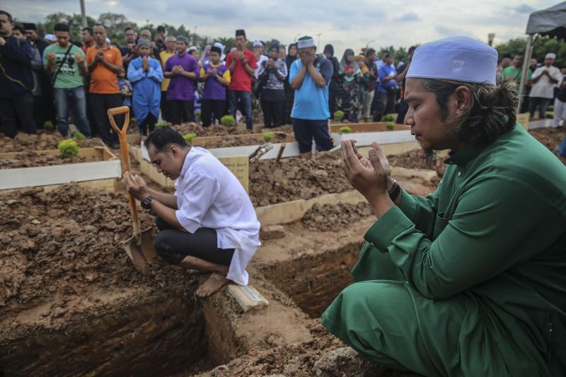 Family members perform prayers for victims of the tahfiz school fire during a mass funeral at the Tanah Perkuburan Islam Raudhatul Sakinah in Gombak September 15, 2017. 