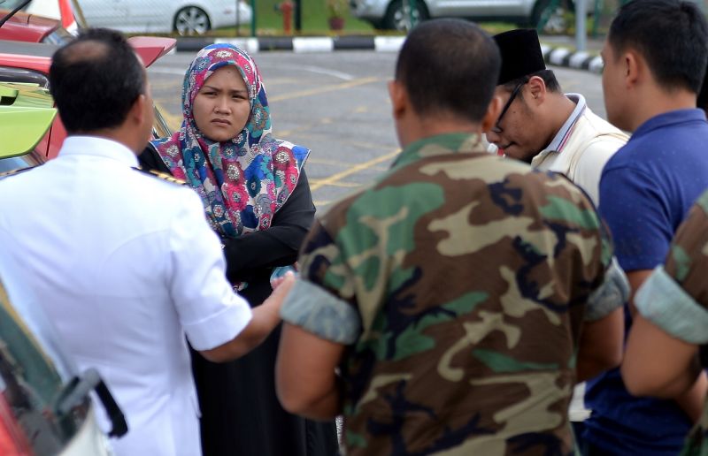 Isteri kepada salah seorang anggota TLDM yang meninggal dunia Mohd Baihaqy Nik Mat, Noor Bazlin Mohammad (dua, kiri) kelihatan sugul ketika menunggu jenazah suaminya di Jabatan Forensik Hospital Raja Permaisuri Bainun hari ini. u00e2u20acu201d Foto Bernama