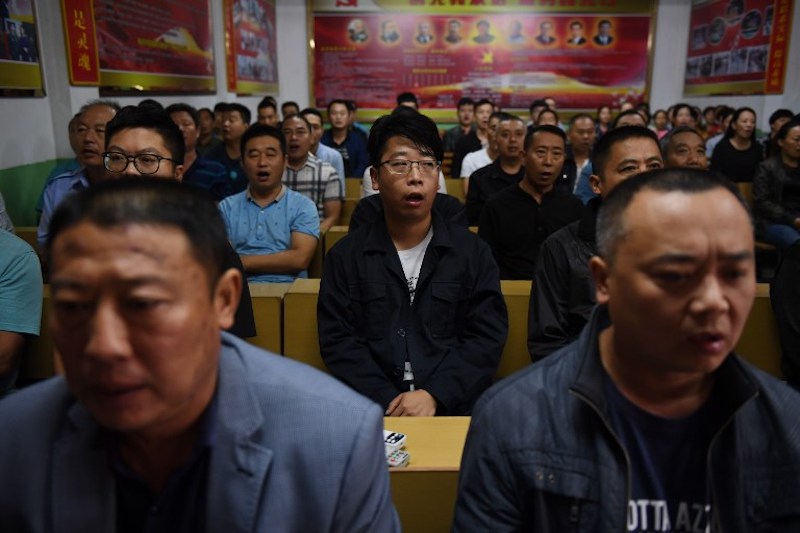 Factory managers singing communist ‘red’ songs at the start of their work day, during a journalist visit in Nanjie village, in China’s central Henan province, September 27, 2017. — AFP pic