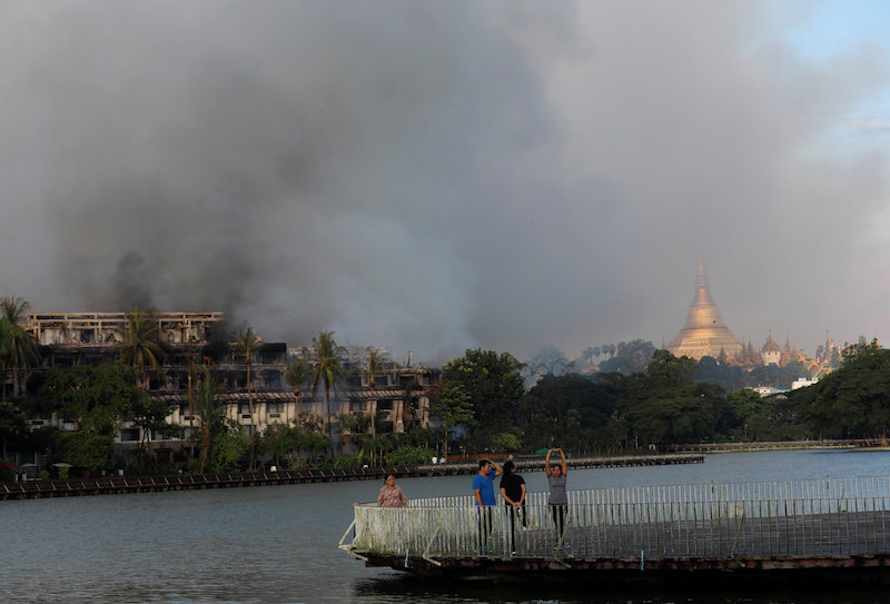 People do exercises near a fire at Kandawgyi Palace Hotel in Yangon October 19, 2017. u00e2u20acu201d Reuters pic