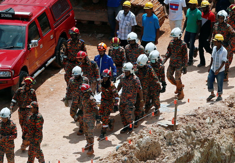Rescue workers carry the body of a landslide victim at a construction site in Tanjung Bungah, a suburb of George Town, October 22, 2017. u00e2u20acu201d Reuters pic