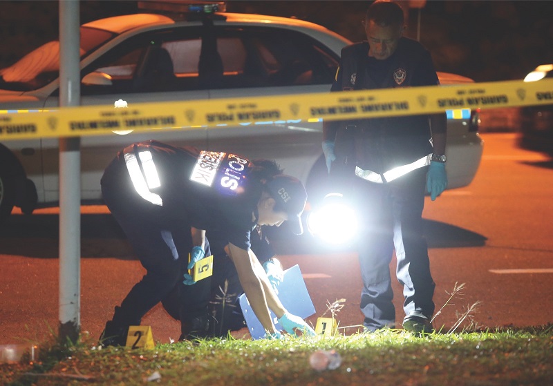 Police forensics personnel look for clues at scene of the shooting. u00e2u20acu201d Picture by Sin Chew