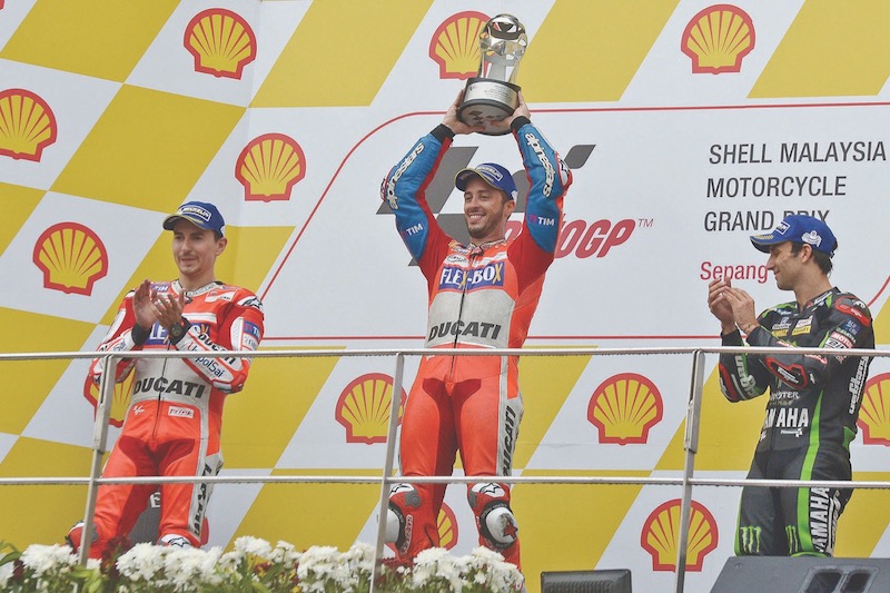 Dovizioso (centre) celebrates as victory keeps his slim hopes of winning the MotoGP title alive. u00e2u20acu201d Malay Mail pic
