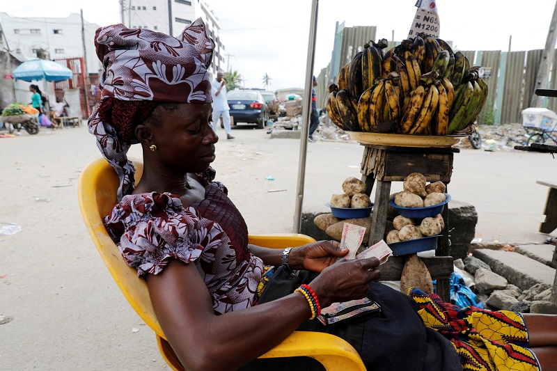 A woman selling plantain along a road counts the Nigerian naira near a currency exchange market in Ikeja district in Lagos, Nigeria August 12, 2017. u00e2u20acu201d Reuters pic