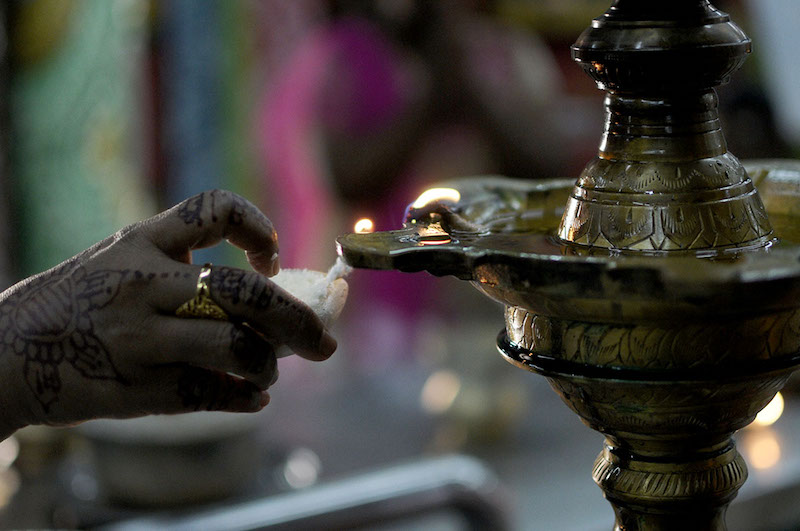 A Hindu devotee lights an oil lamp during Deepavali prayers at a temple in Puchong, Selangor, October 18, 2017. u00e2u20acu201d Picture by Miera Zulyana