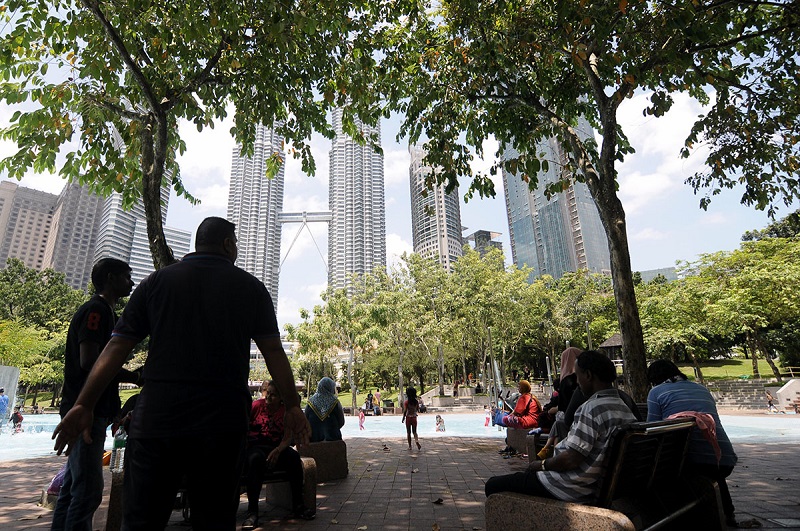 People rest under the shade of trees during a hot day at the KLCC park in Kuala Lumpur October 23, 2017. u00e2u20acu201d Picture by Miera Zulyana