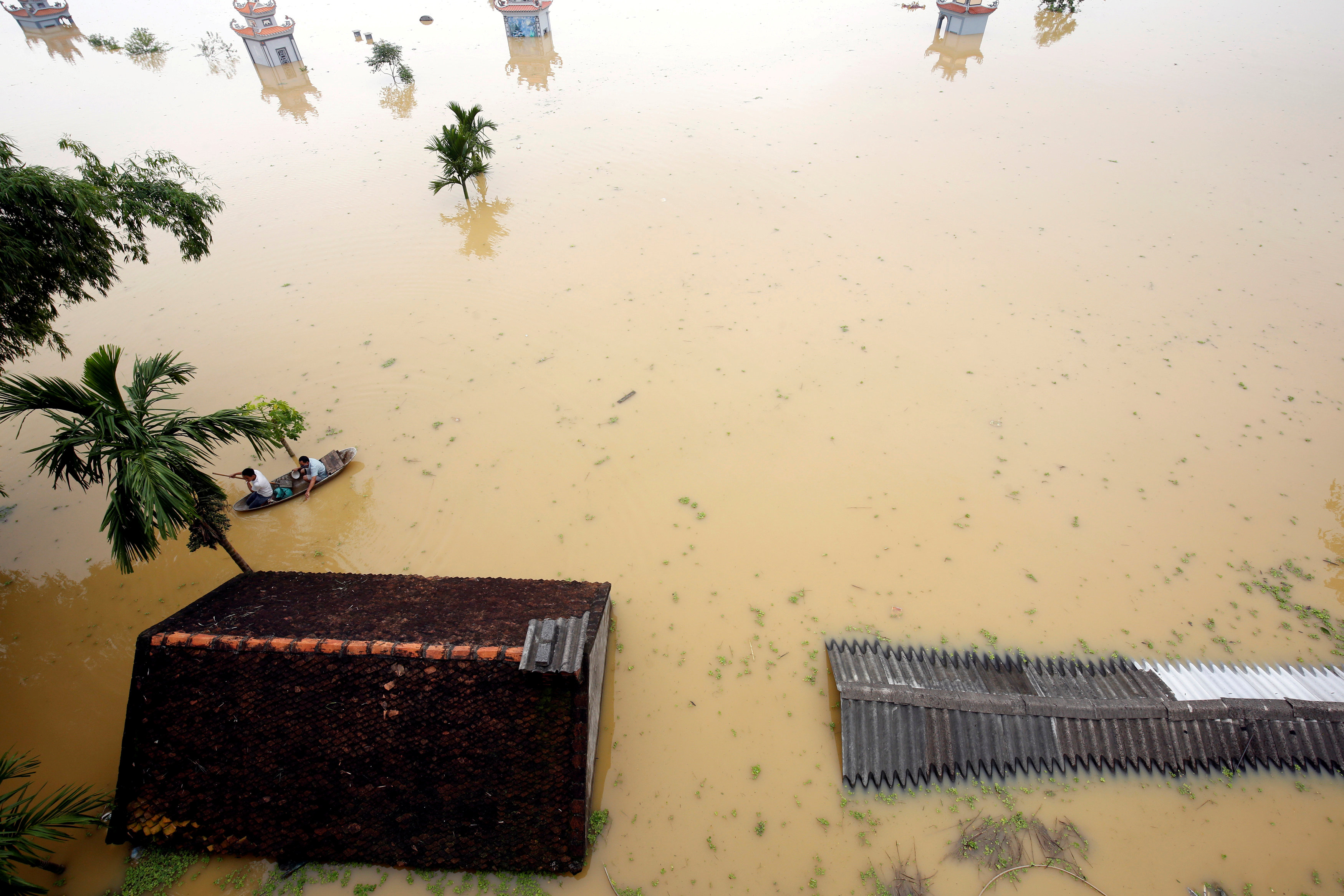 Farmers paddle in a boat at a flooded village after a tropical depression in Hanoi, Vietnam October 13, 2017. u00e2u20acu201d Reuters pic