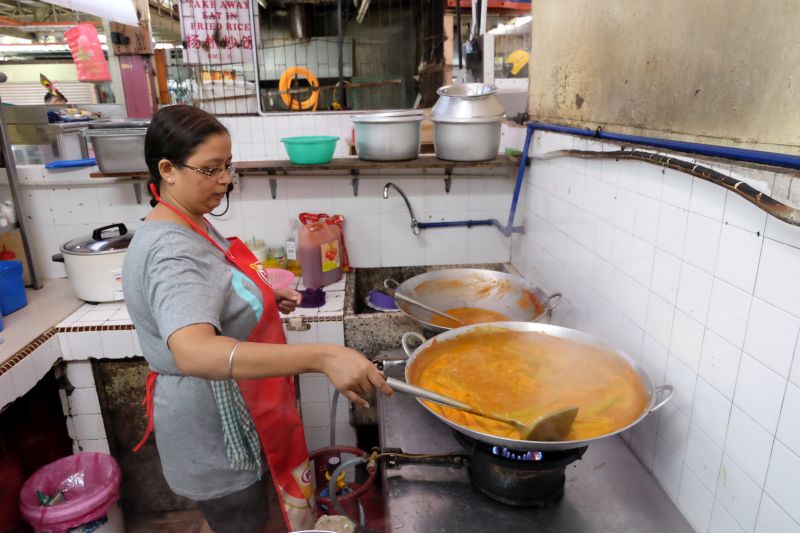 Nandiini preparing the curry at the stall. — Picture by K.E. Ooi